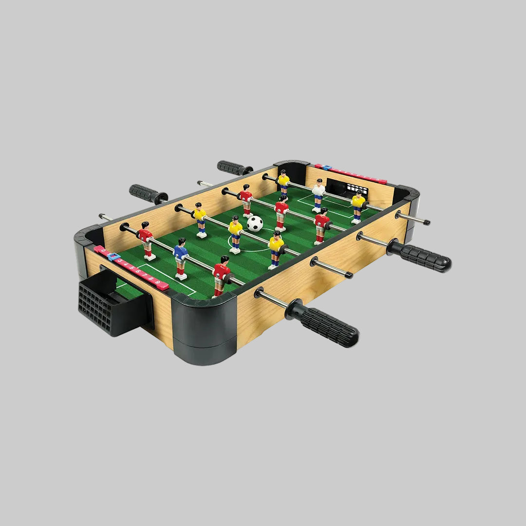 The AMBASSADOR Green Mini Tabletop Foosball Game set up on a table, highlighting its portable size
