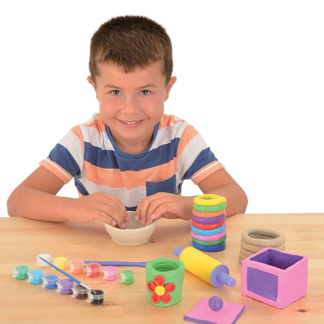 Child creating a coil pot with educational toys for kids clay tools.
