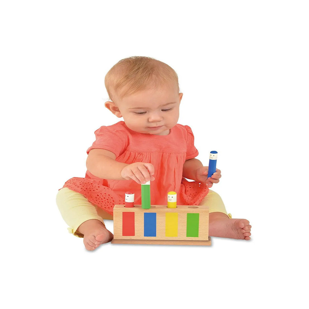 A toddler's hand pressing one of the colourful figures to make it bob up