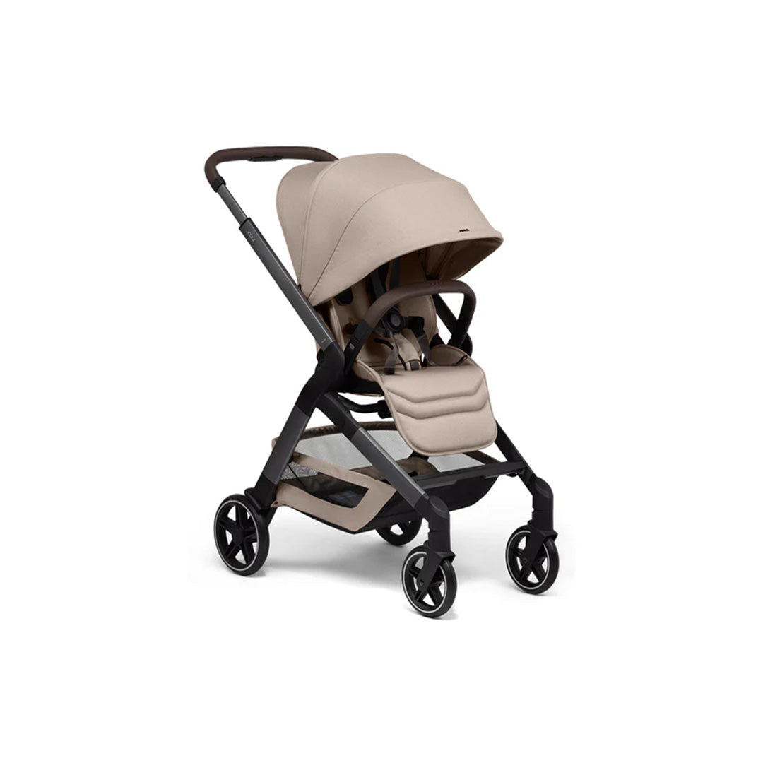 A lifestyle shot of the Sandy Taupe Joolz Hub² being pushed on a sidewalk, highlighting its modern neutral tone that complements any urban style.