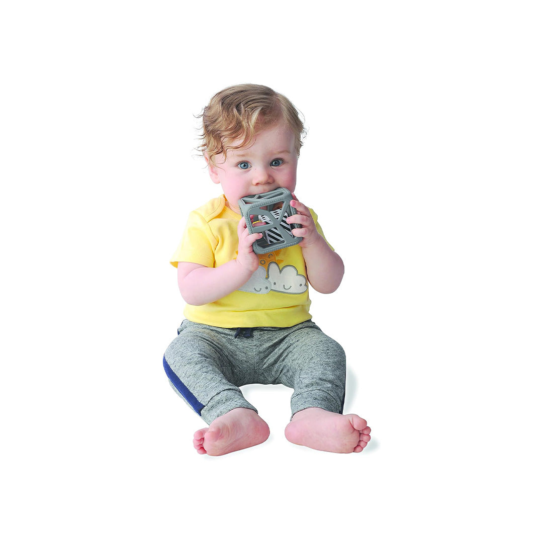 Baby playing with non-toxic toys rattle on a baby play mat.
