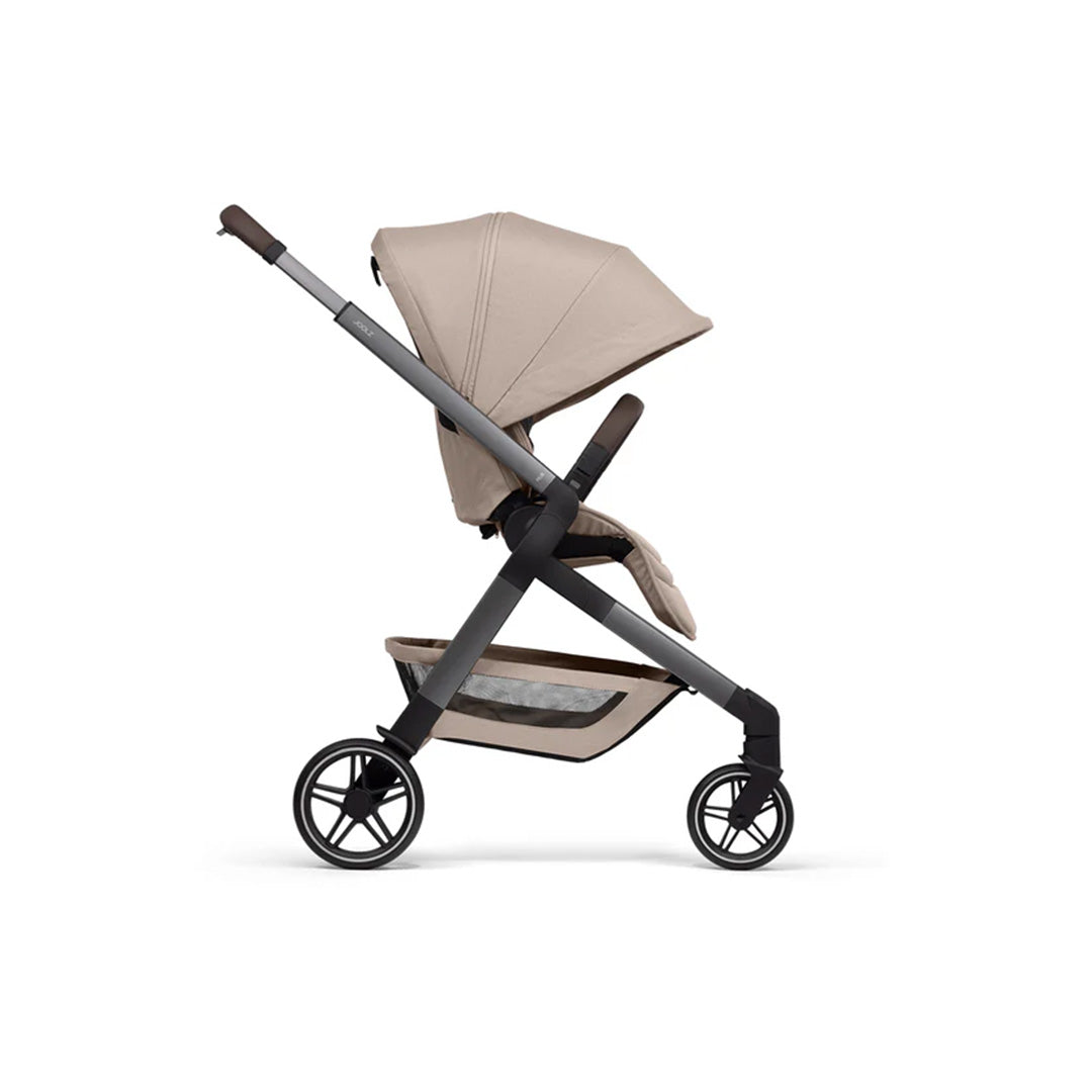 Side profile of the Sandy Taupe stroller seat fully reclined to a flat position, demonstrating its suitability for newborns and sleeping toddlers.